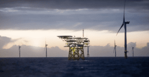 An offshore HVDC platform with an offshore wind farm in the background