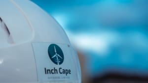 The back of a helmet worn by a Taylor Hopkinson QAQC offshore wind contracting specialist working on Inch Cape Offshore Wind farm, with the wind farm logo visible.